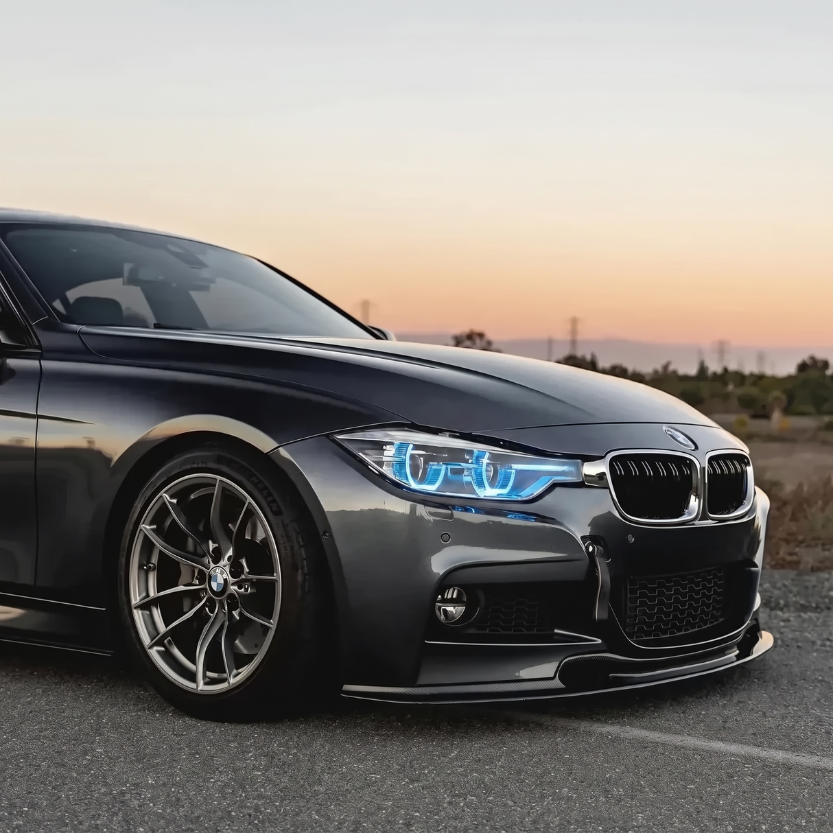 BMW F30 3 Series blue DRL three quarter view at sunset